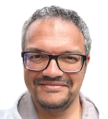 Head and shoulder portrait of speaker Dr David Rosario. A man with a trimmed beard and moustache and black spectacles